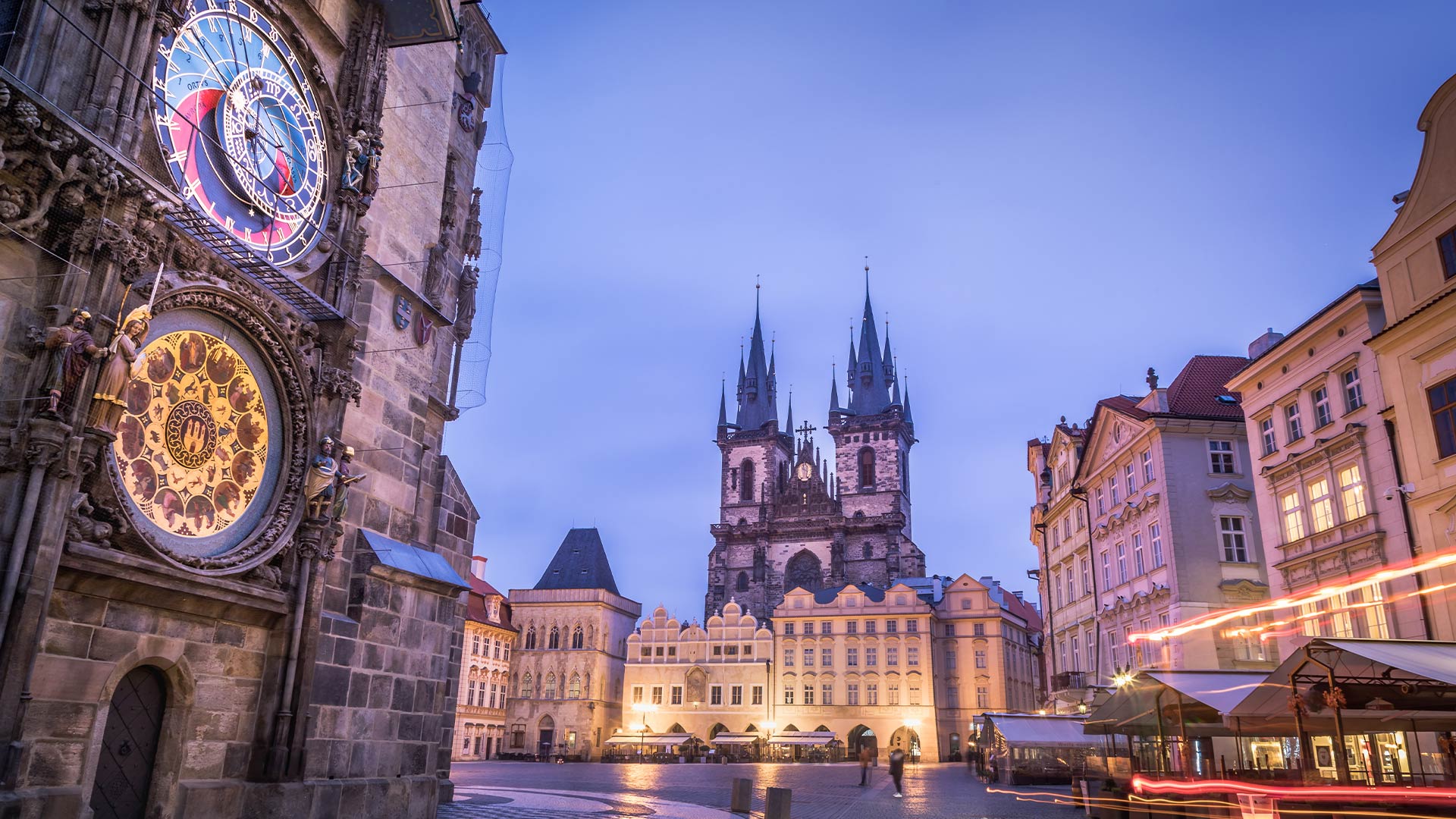 Astronomical Clock and Týn Church lit up at dusk in Prague
