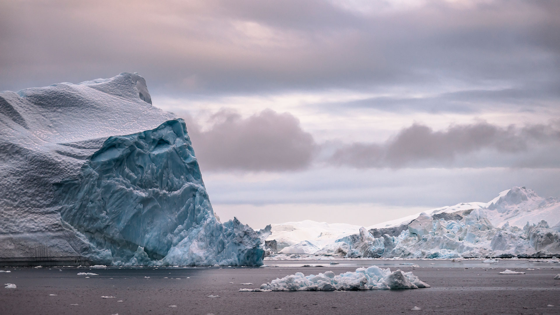 Small boat dwarfed by Iceberg near Tasiilaq