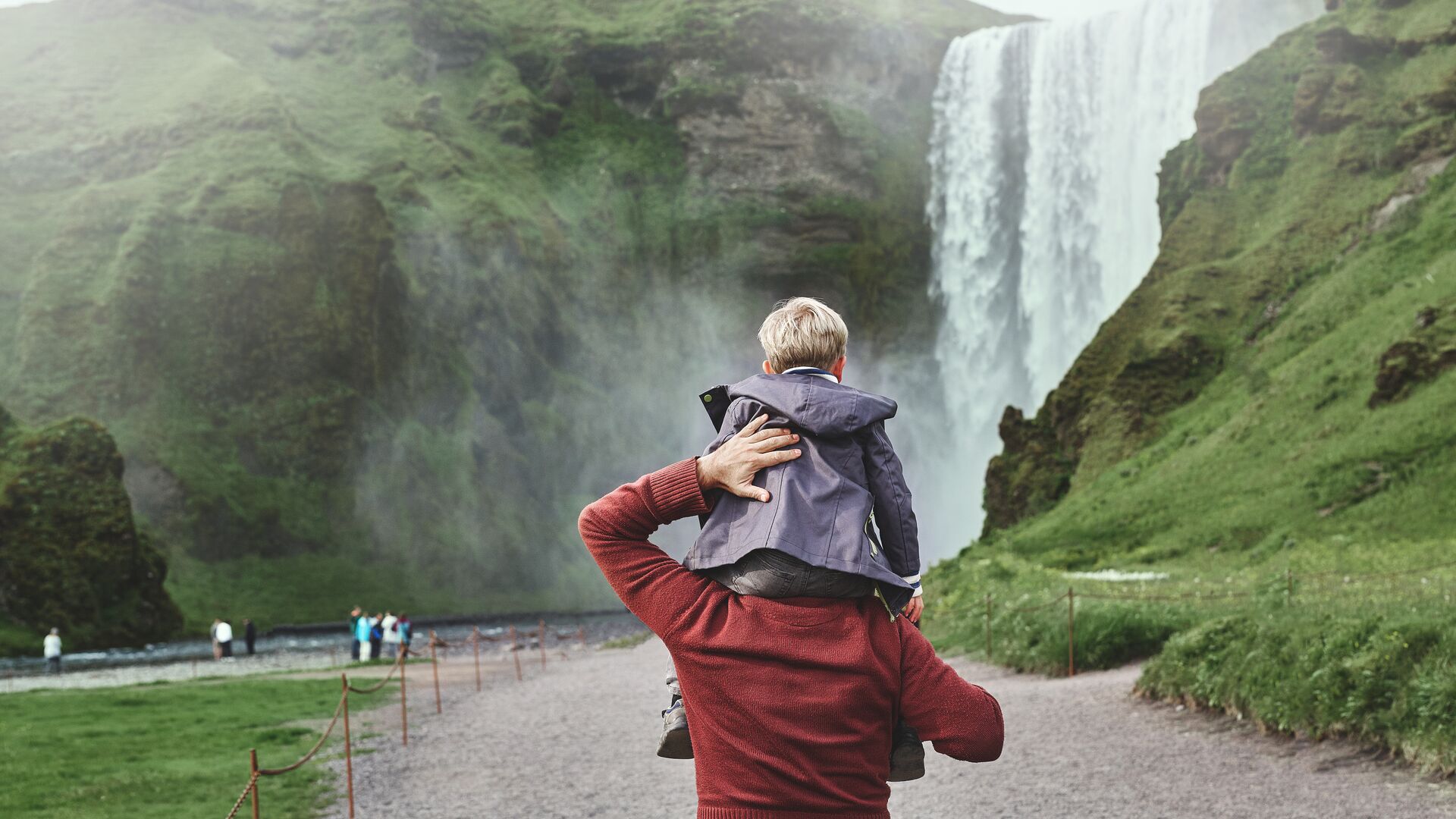 Family visiting Skógafoss