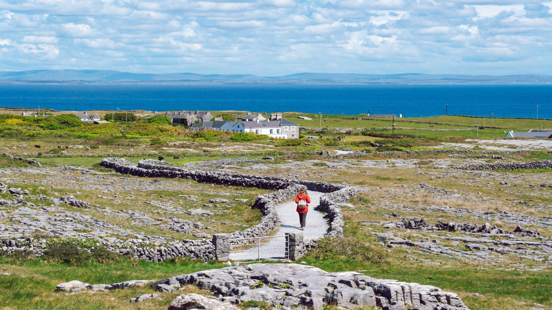 Hiker on a stone-walled path on Inishmore, Aran Islands, Ireland