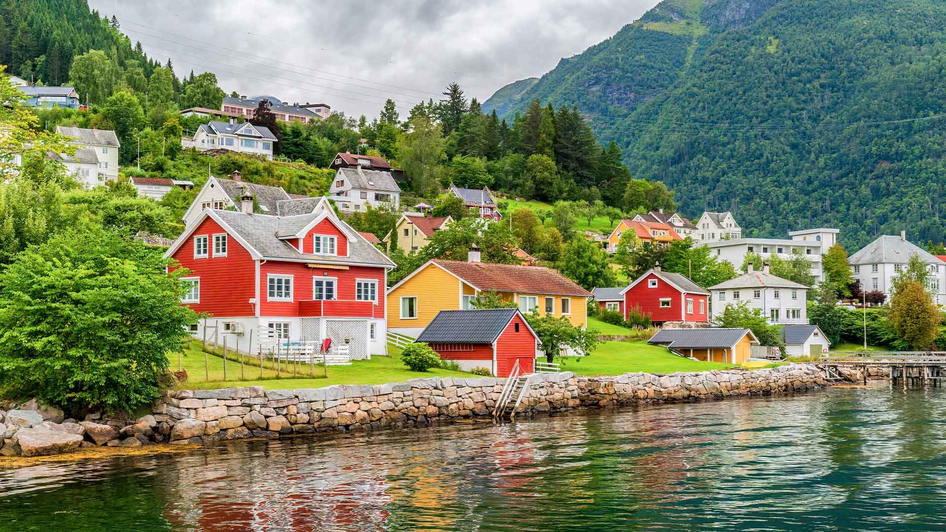 Traditional wooden Nordic houses along Sognefjord shore Balestrand 