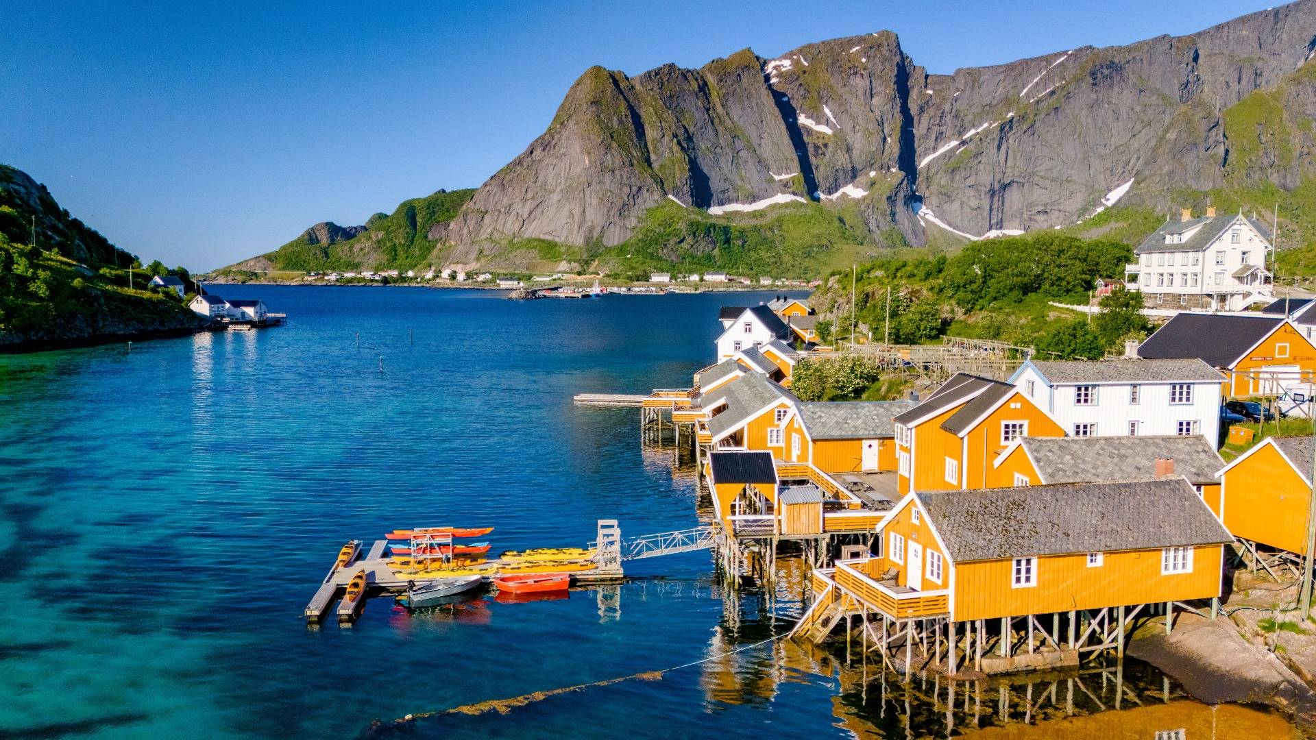 Yellow wooden cabins on stilts on a fjord in Sakrisoy, Lofoten, Norway