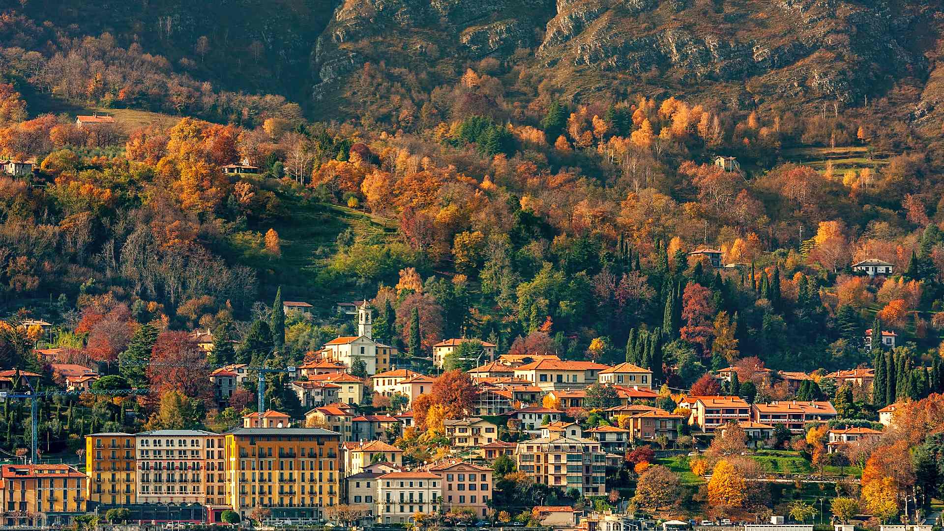 Lakeside town on Lake Como, Italy, framed by autumn trees