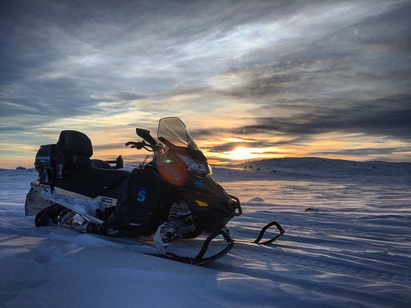 Snowmobiling into an arctic sunset in Norway