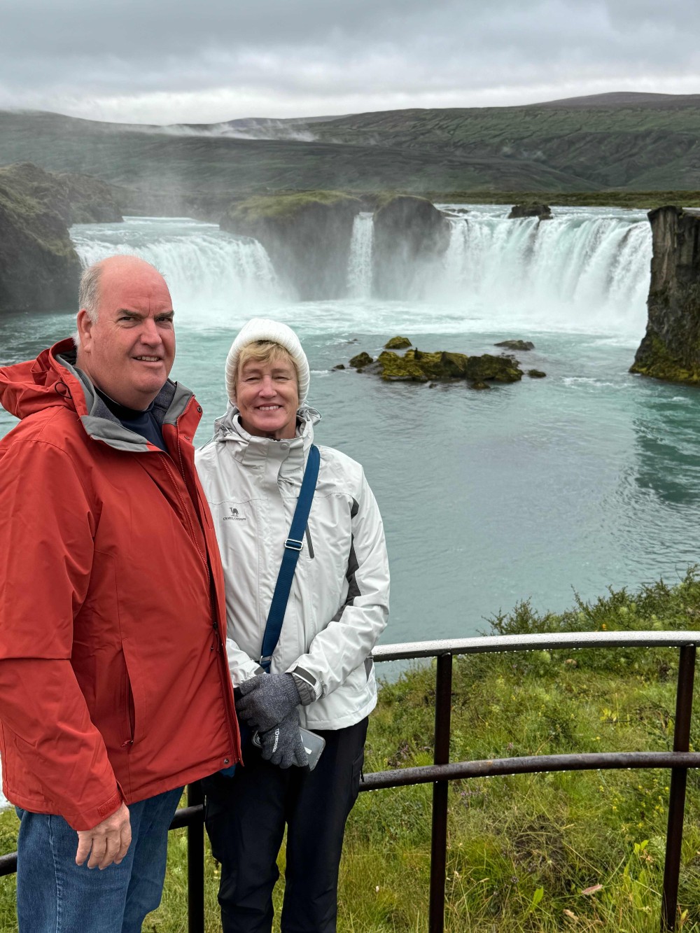 Senior self-drive travellers enjoying Icelandic waterfall