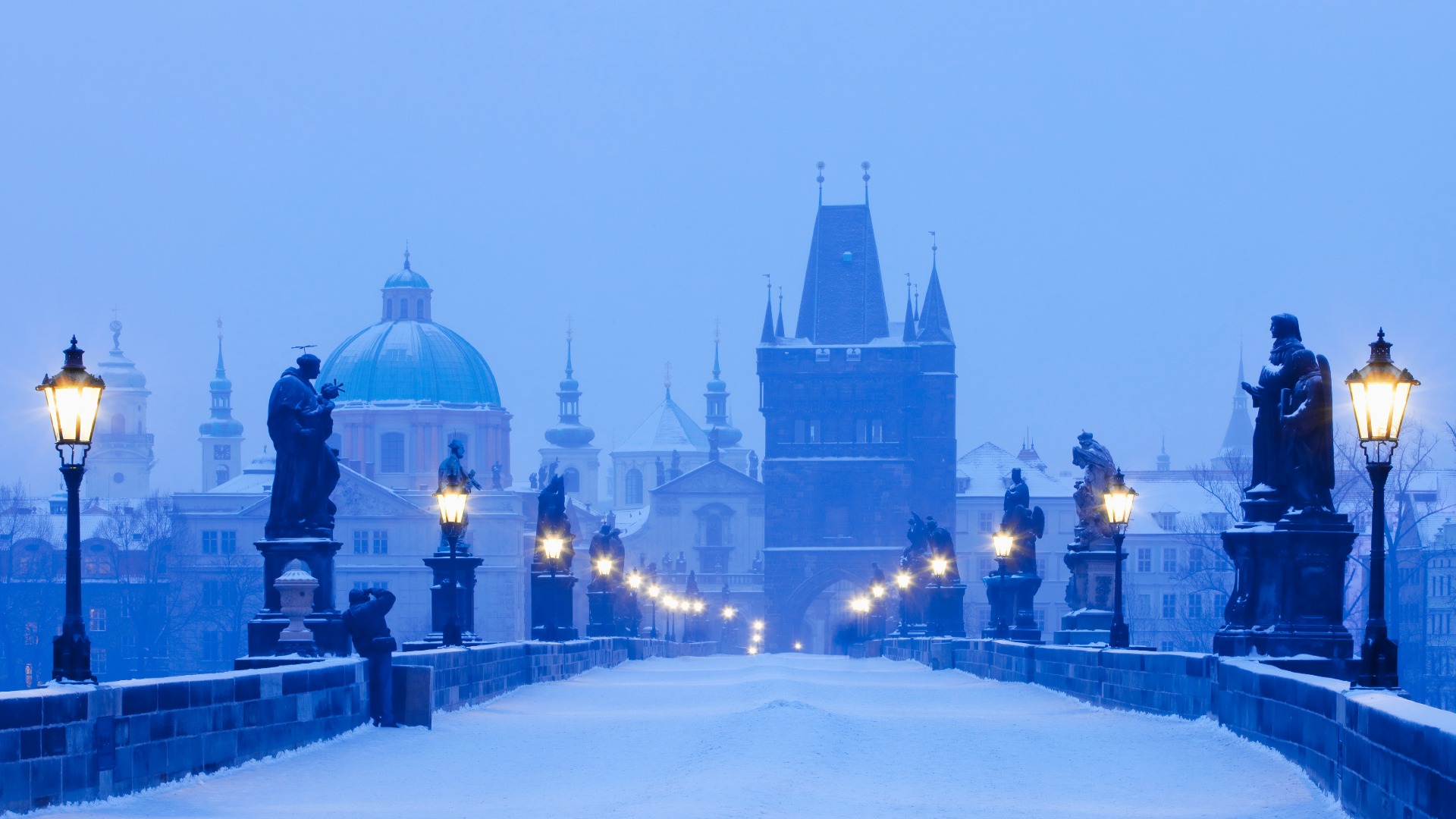 Snow-covered Charles Bridge at dusk