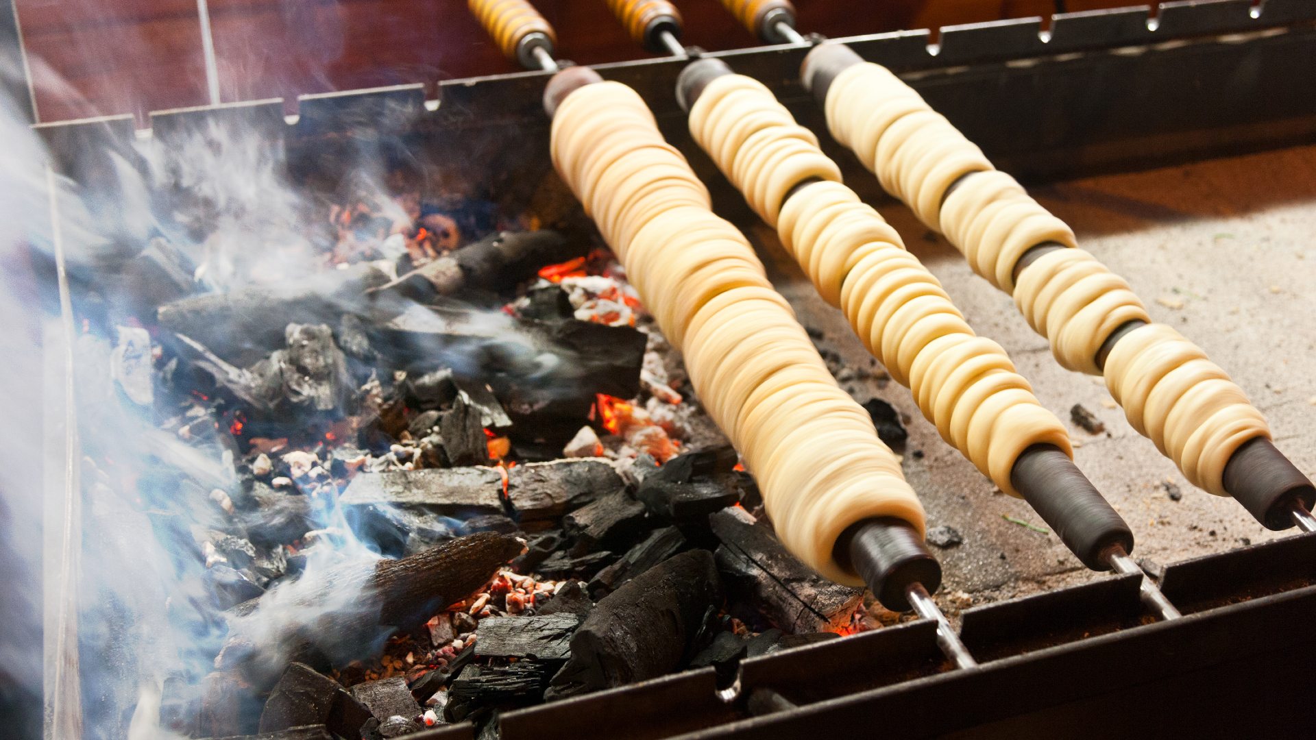 Trdelník chimney cake being prepared at a Christmas market stall in Wenceslas Square, Prague.