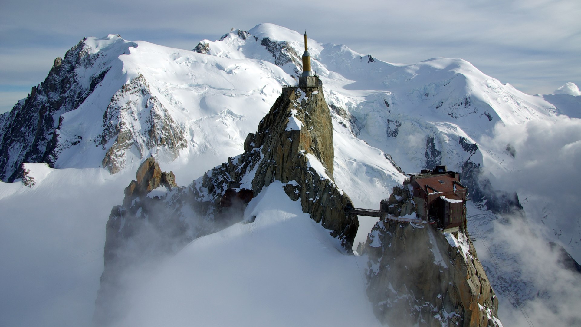 Snow-covered Mont Blanc with the Aiguille du Midi cable car station in the foreground
