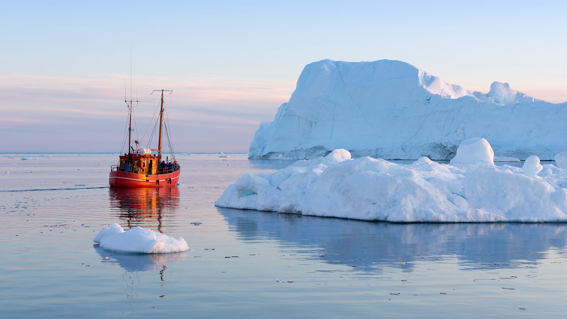 Traditional boat beside an iceberg in Greenland