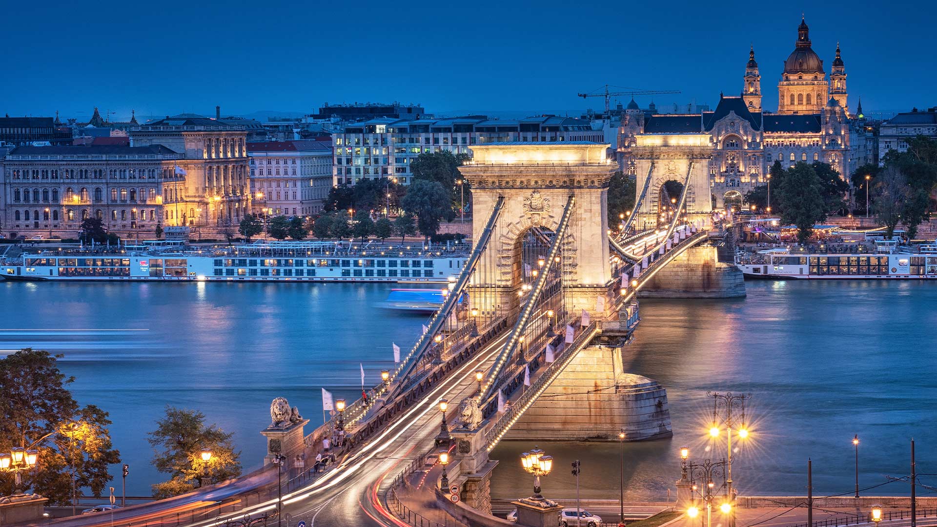 Chain Bridge glowing with lights at dusk in Budapest