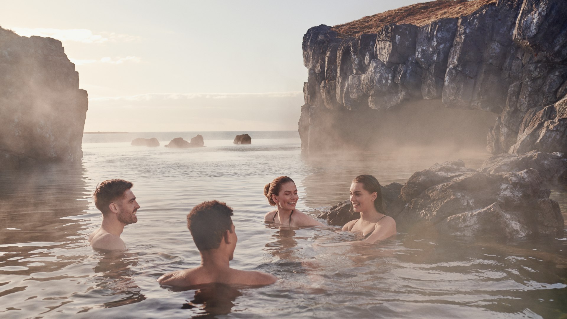 Friends swimming in the Sky Lagoon