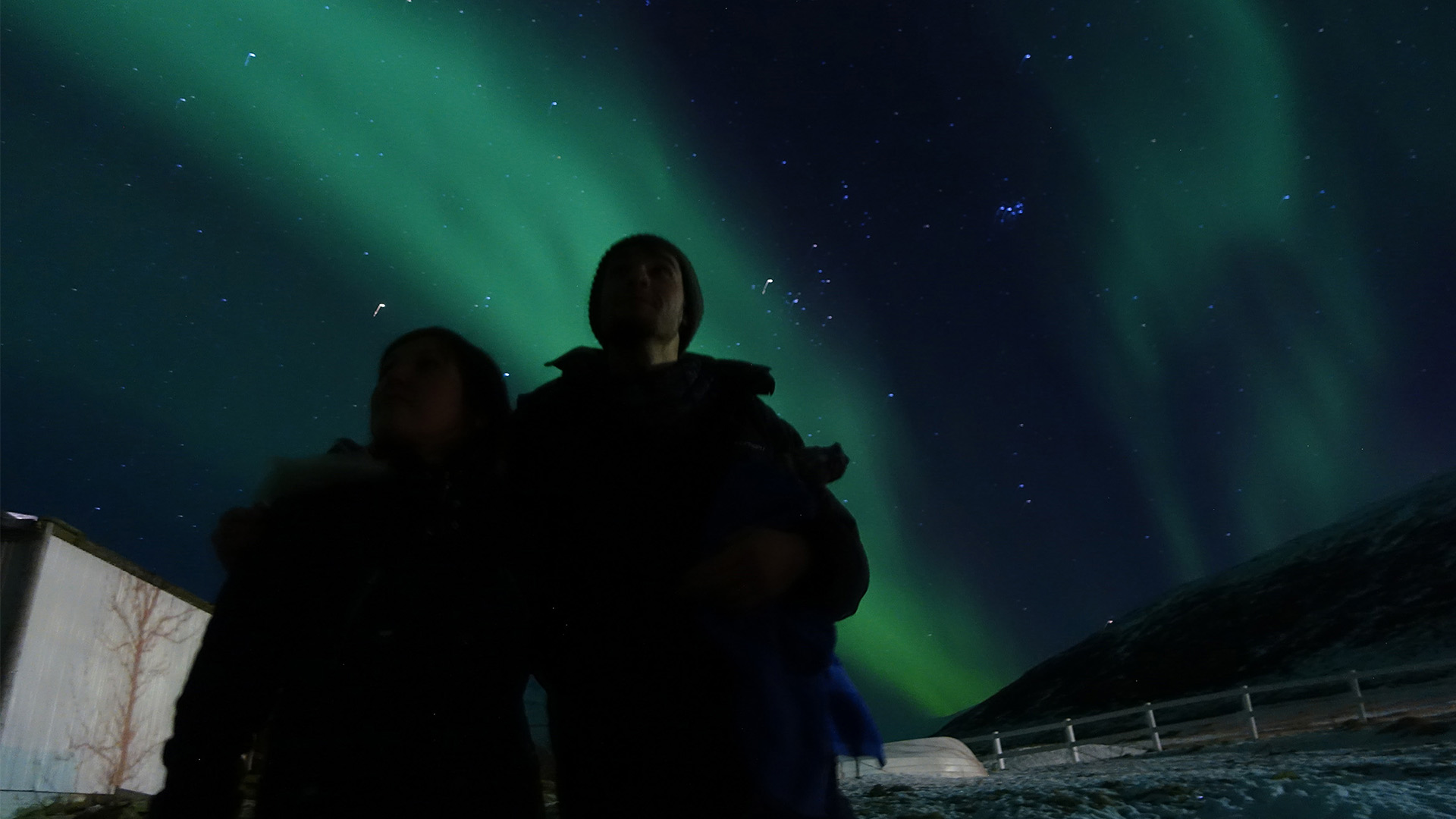 couple standing under northern lights