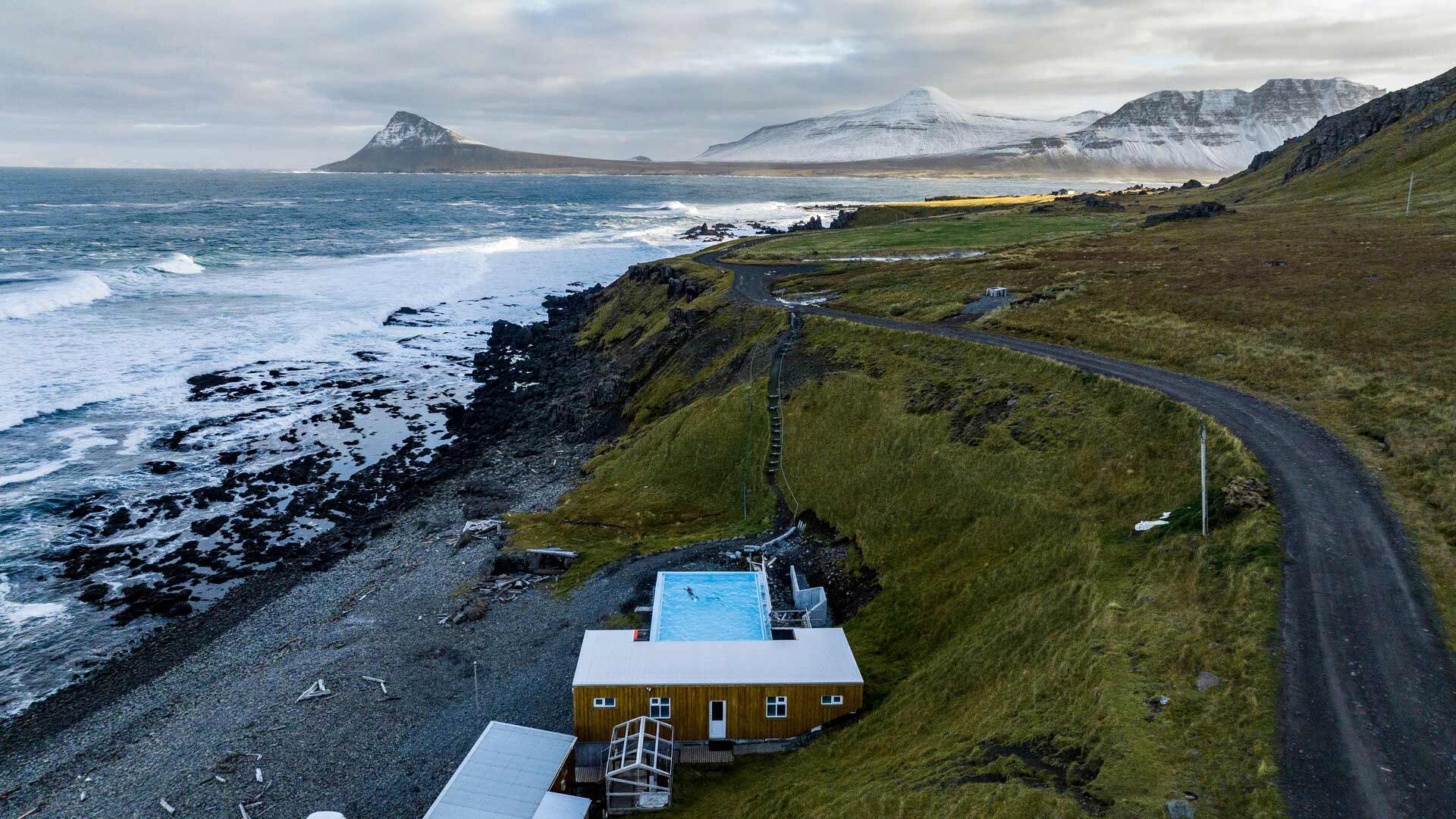 Krossneslaug geothermal pool with snow covered mountains