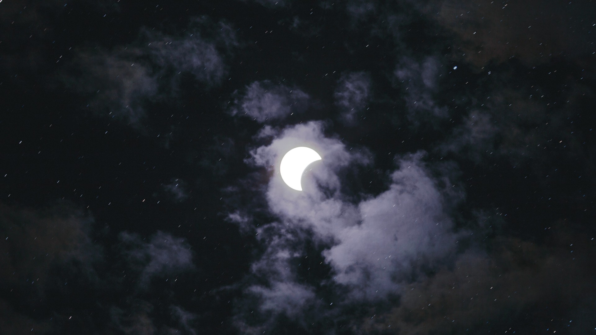 Solar eclipse visible through clouds