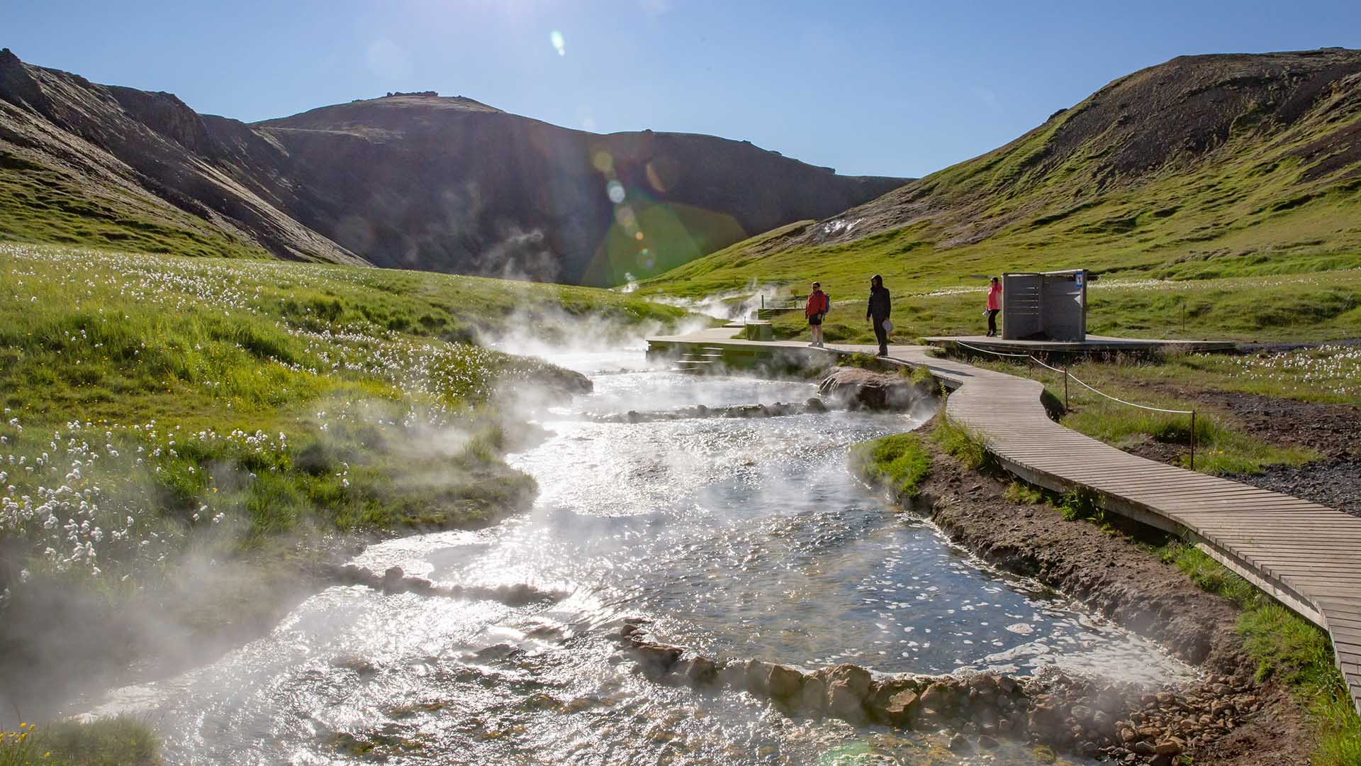 Steam rising from a meandering river through the valley.