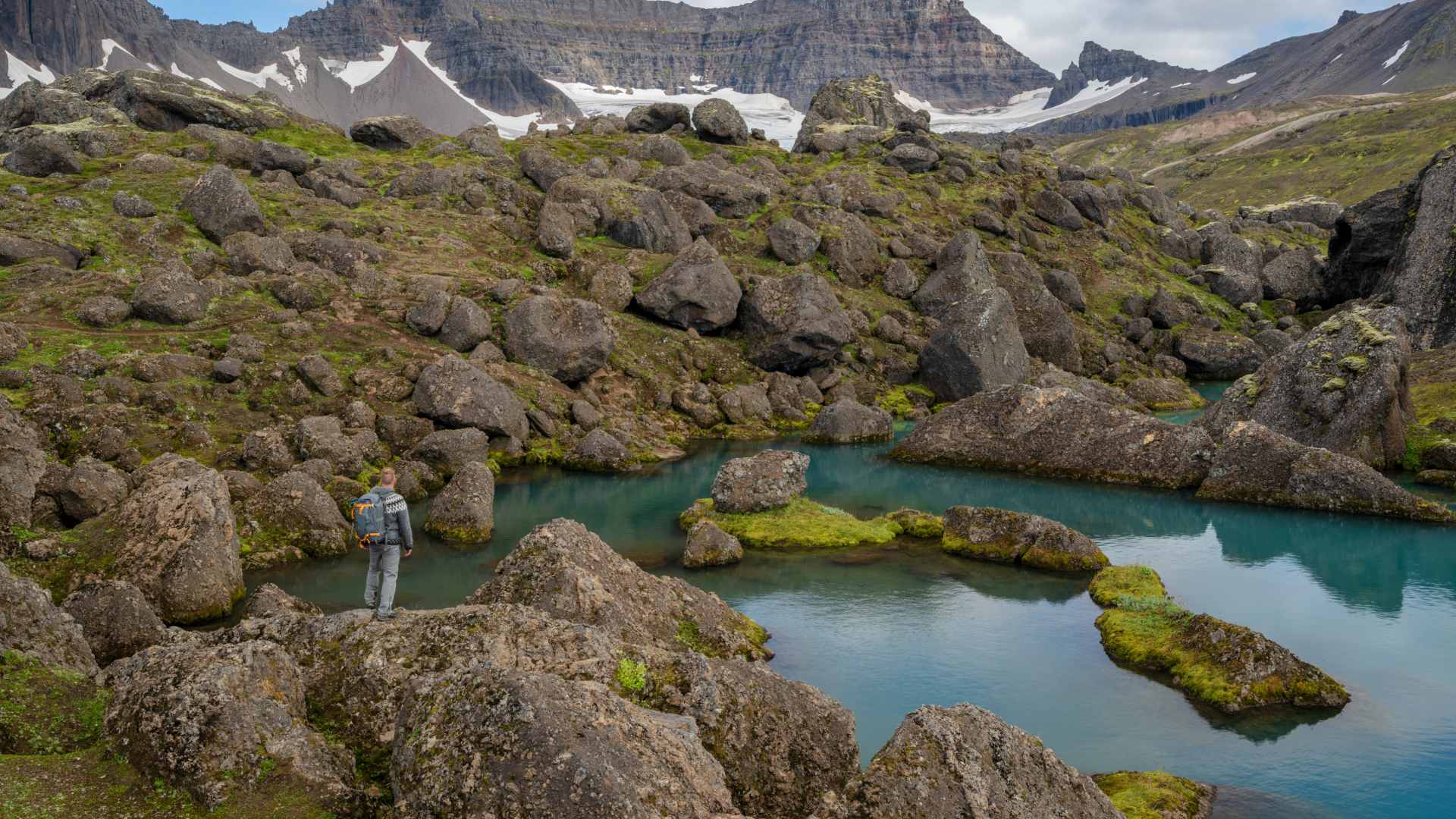 A hiker admiring dramatic views at Stórurð.