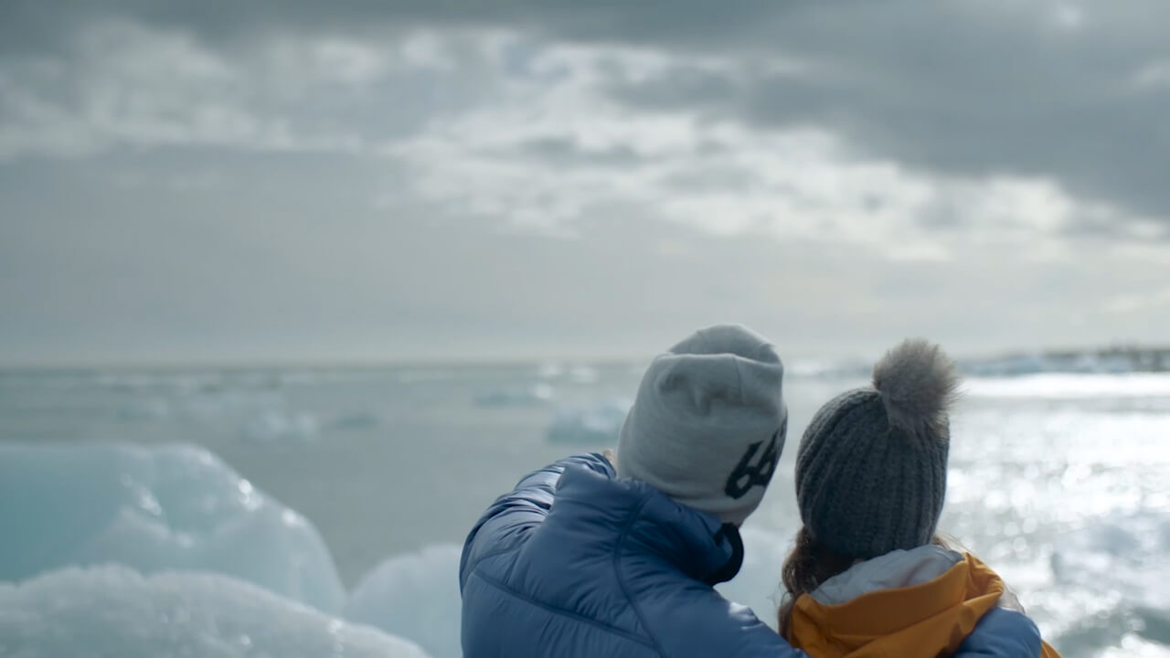 Couple gazing at Jokulsarlon glacier lagoon in Iceland