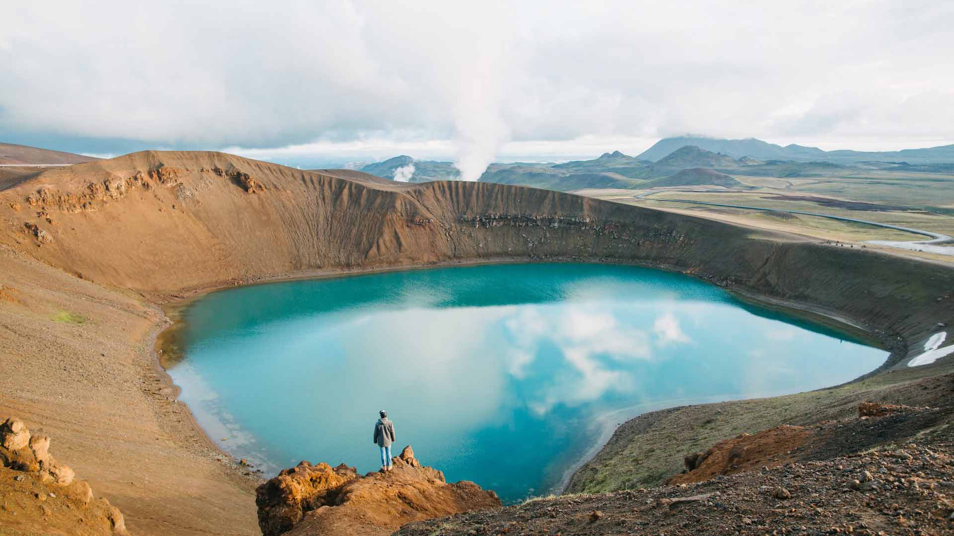 Person standing before blue Lake Viti, North Iceland