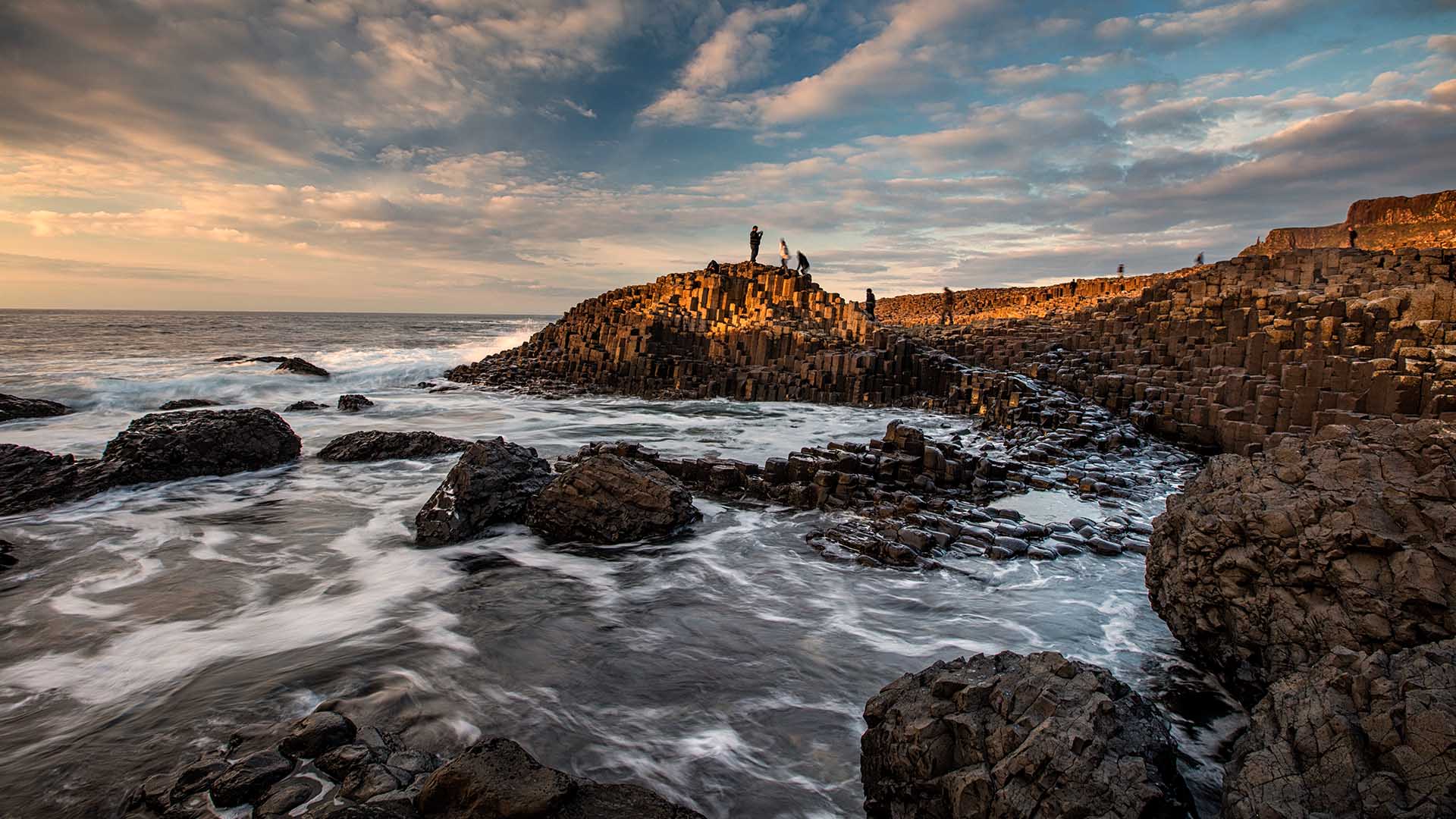 people standing on rocks at giant's causeway