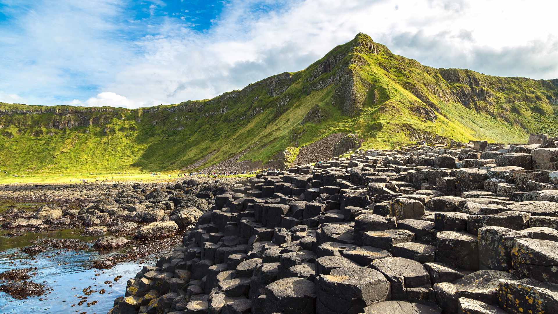 Shoreline view of the Giants Causeway and towering sea cliff in Northern Ireland