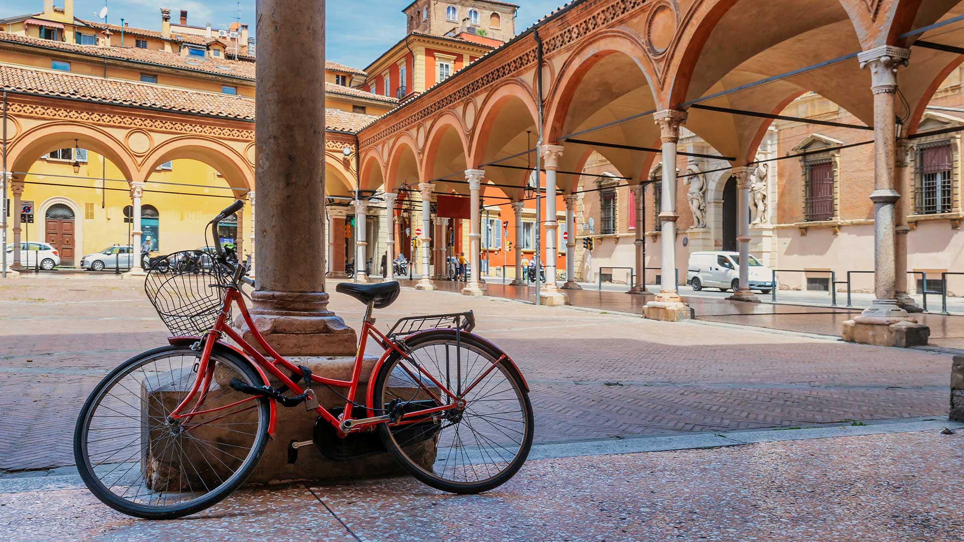 Red bicycle with basket beside basilica of santa maria dei servi in bologna