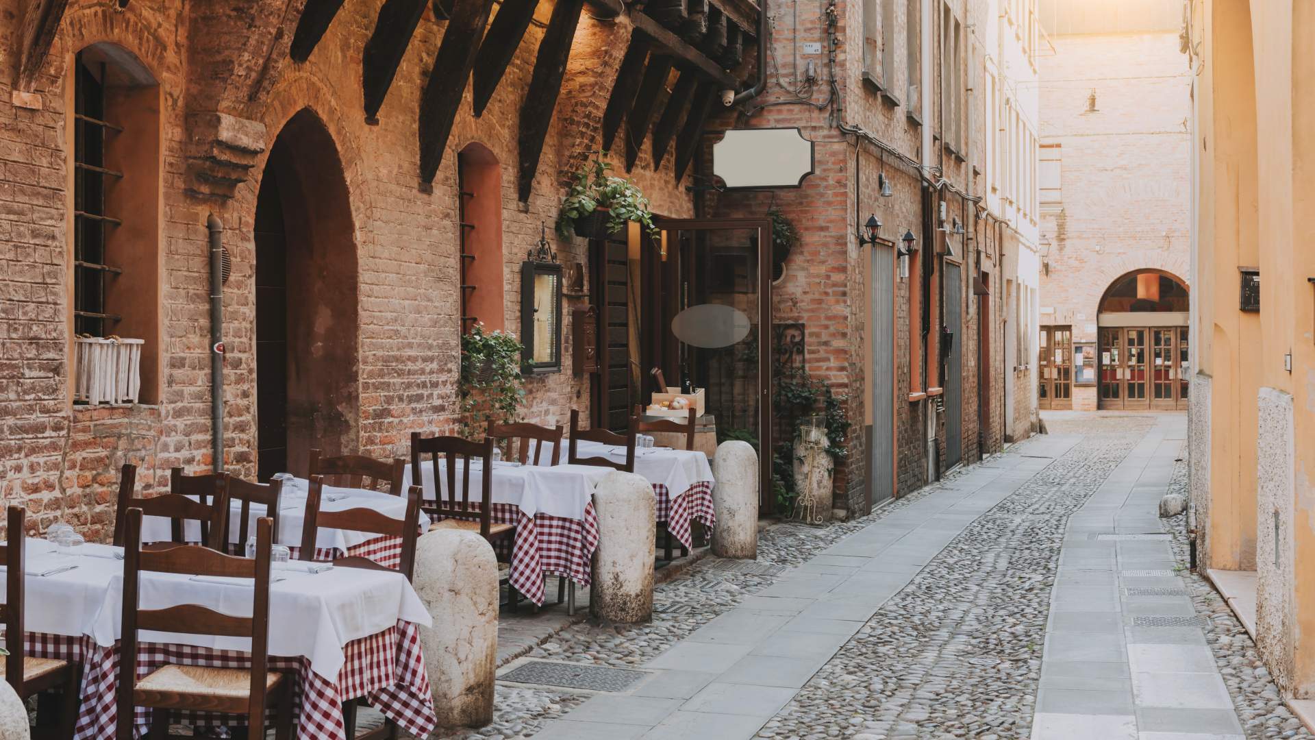 Street lined with authentic dining table and chairs in Emilia Romagna, Italy