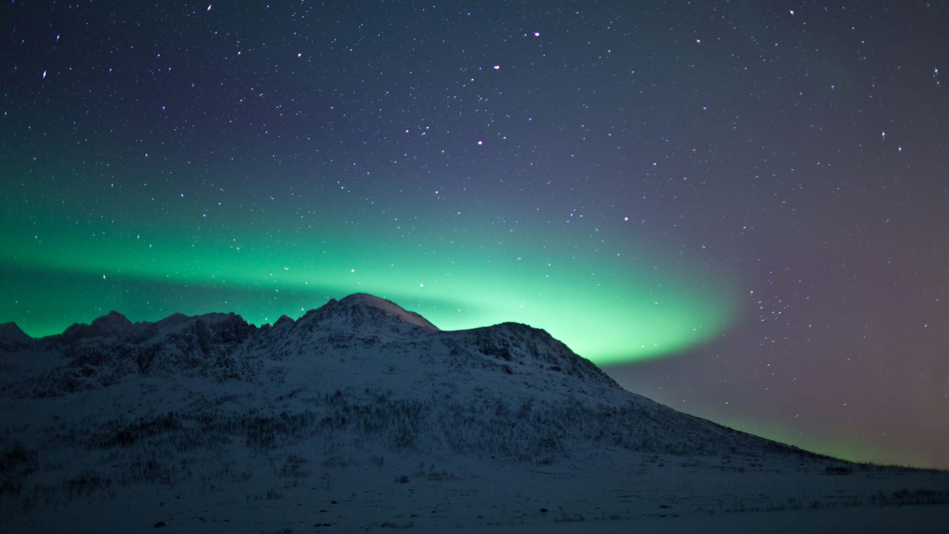 northern lights over snowy mountain