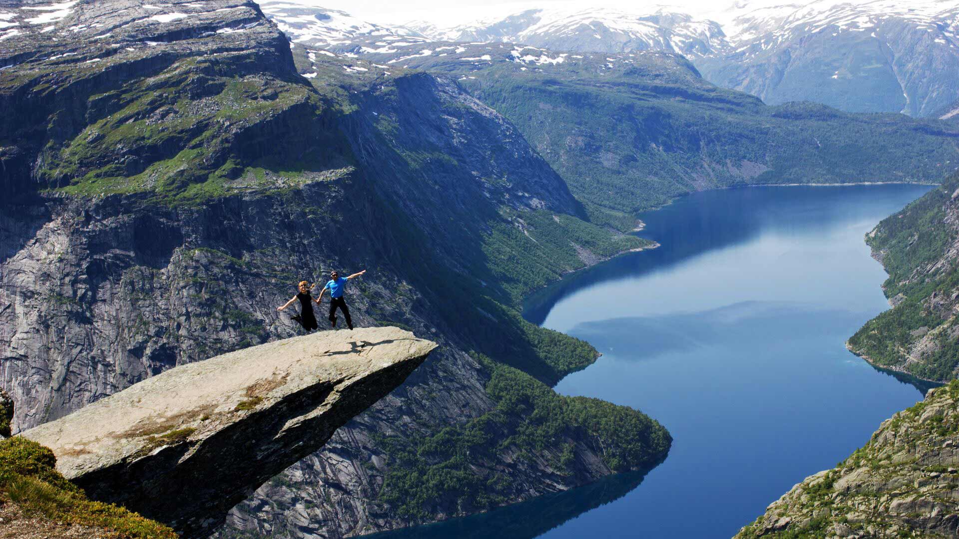 people jumping atop trolltunga