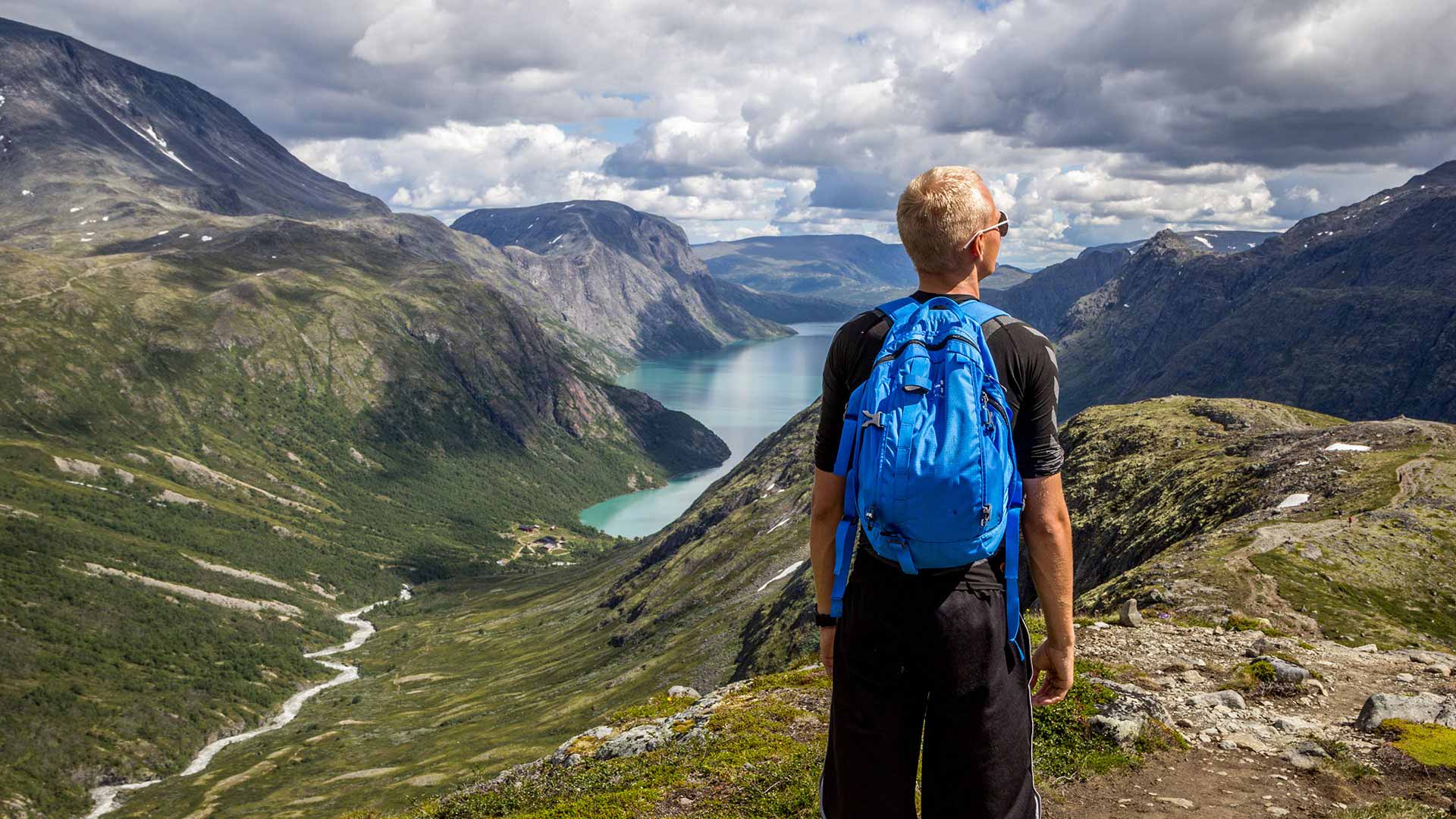man hiking by fjord