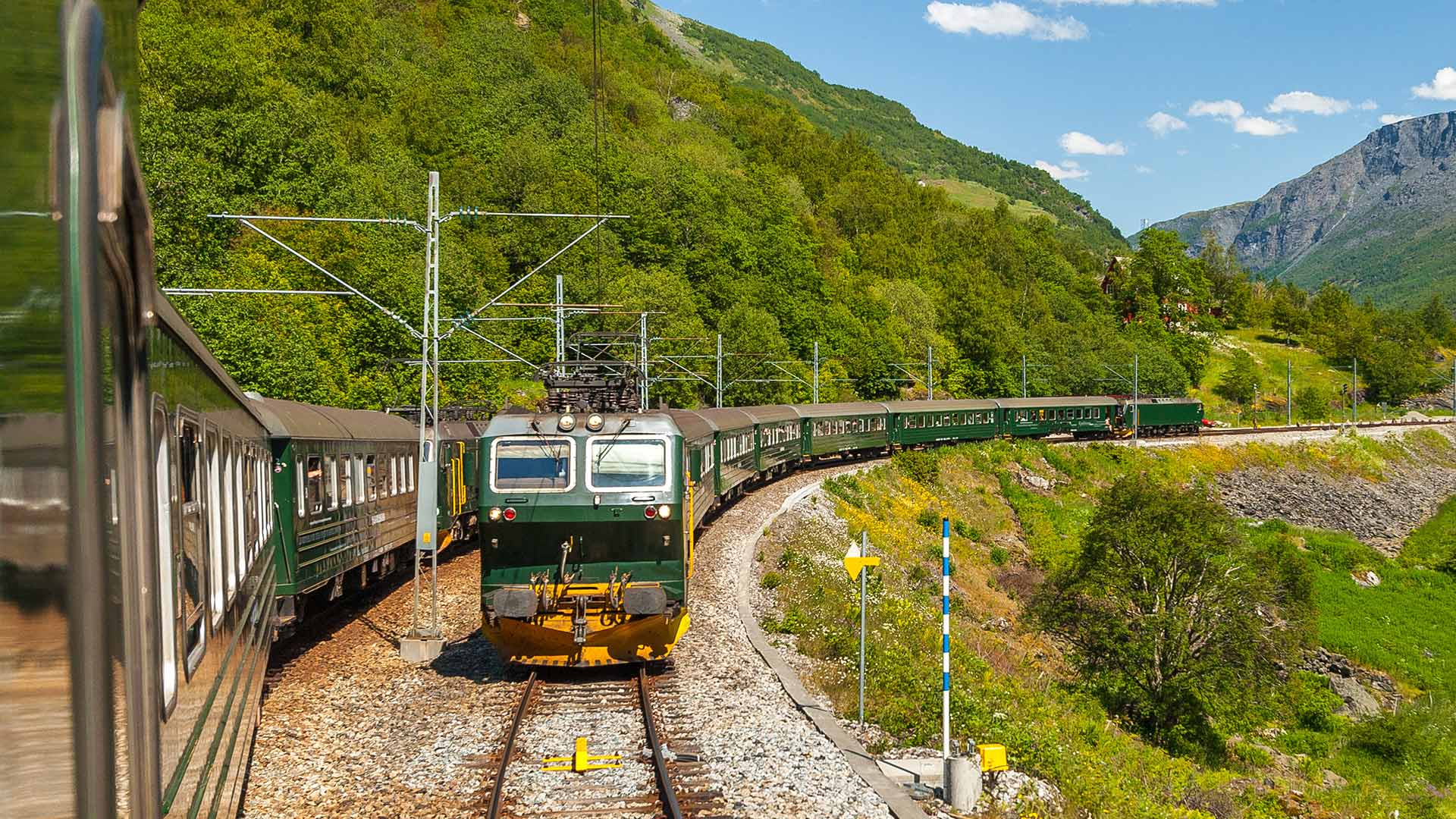 Historic green Flåm Railway train on its mountain route