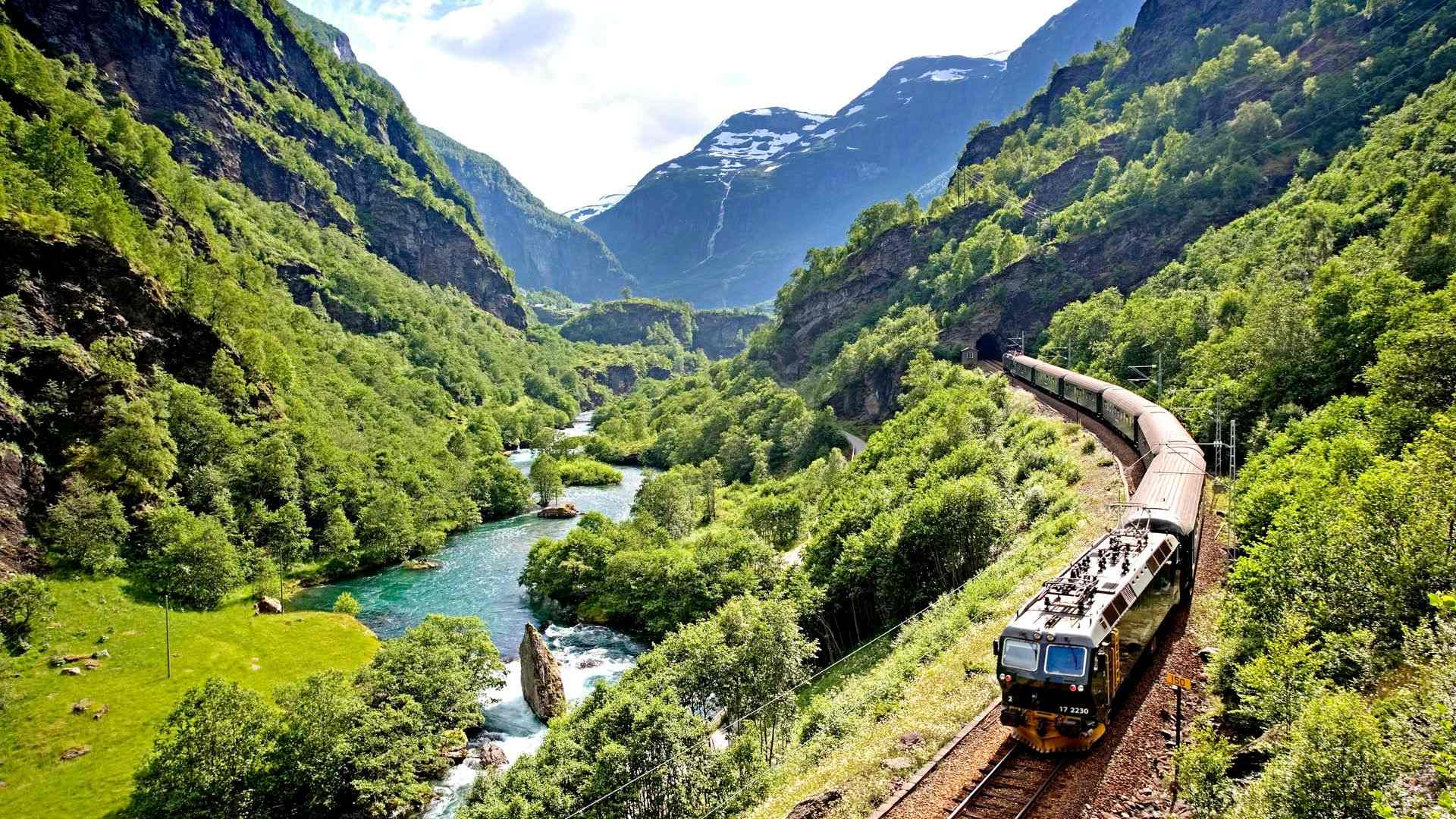 The Flåm railway curving around the green mountains in Norway