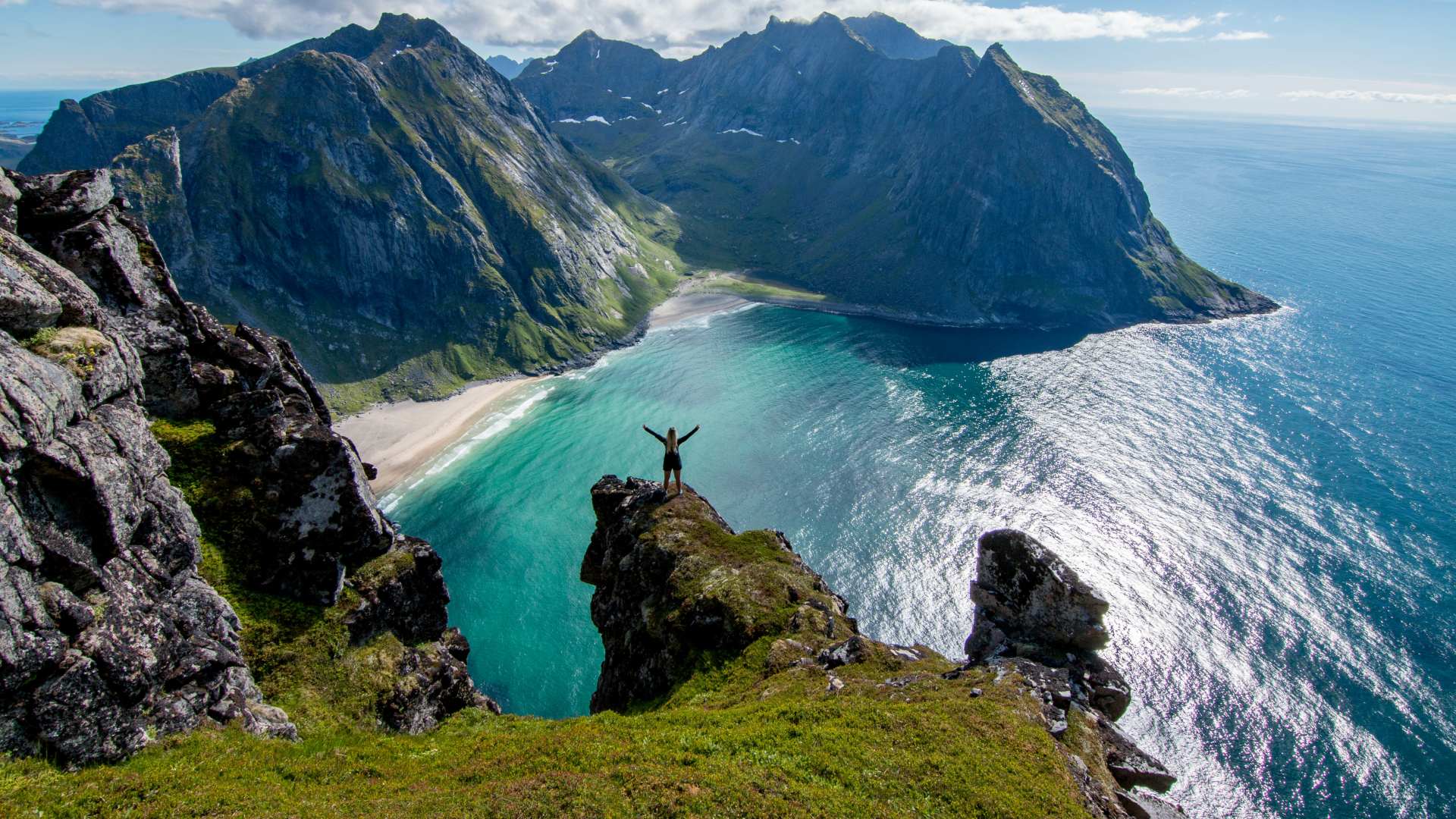 Person hiking overlooking Kvalvika Beach, Lofoten Islands, Norway