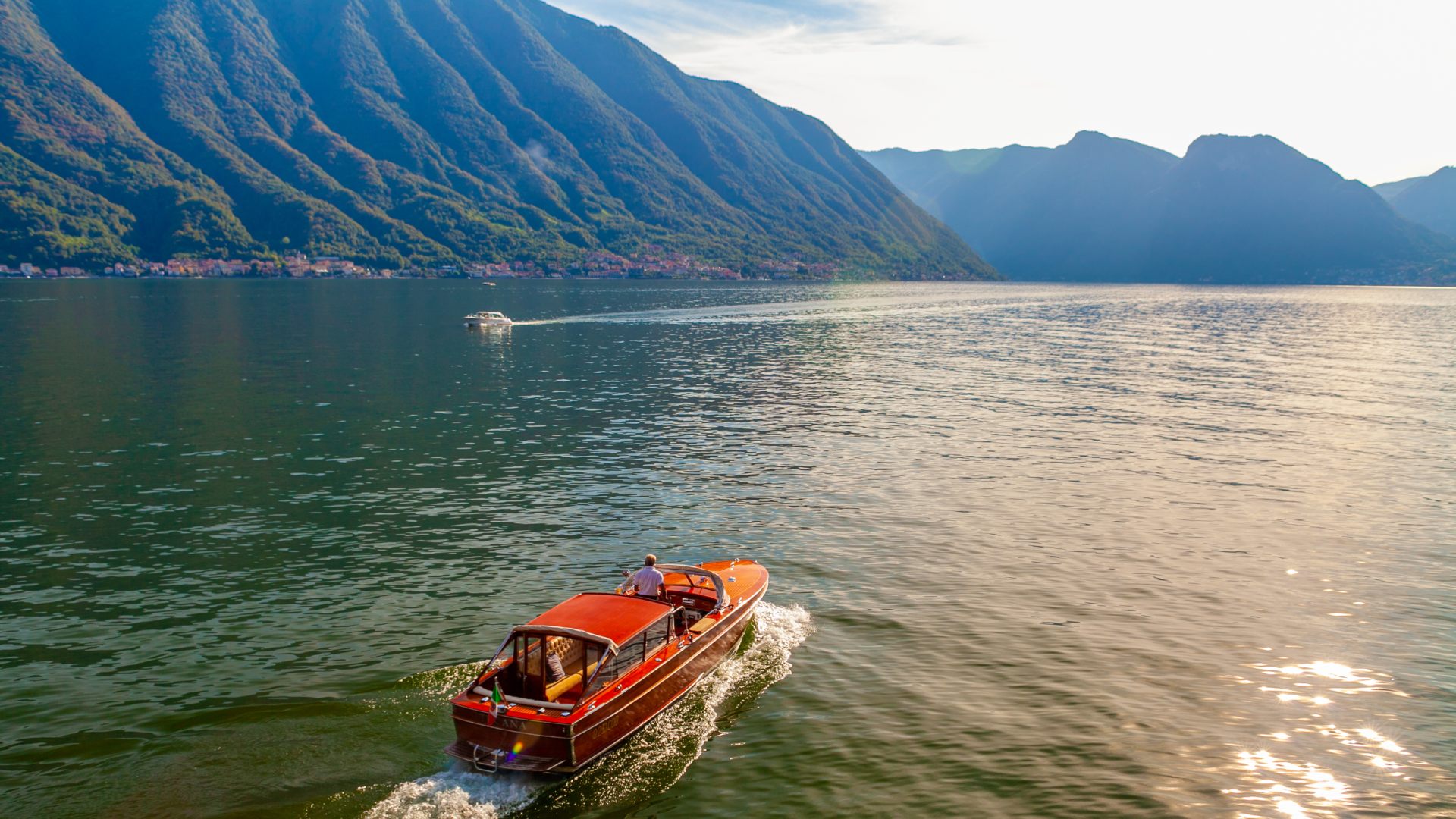 Man on a red boat in Lake Como