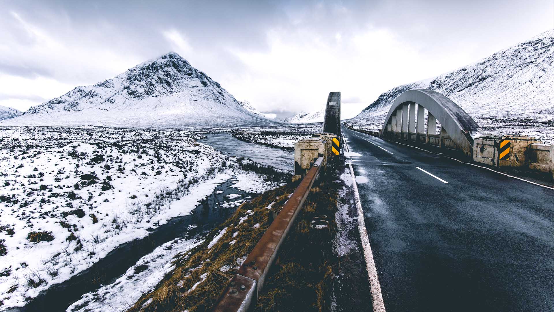 Driving across the Highlands during winter with white mountains ahead