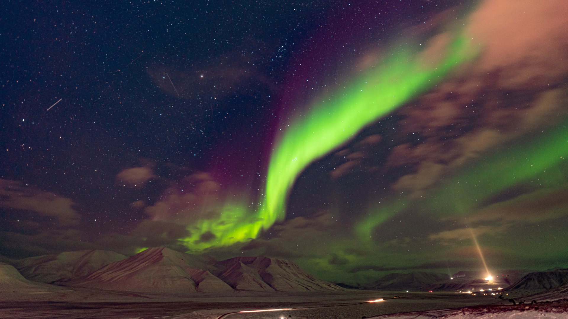 Northern lights dancing above a bay in Svalbard