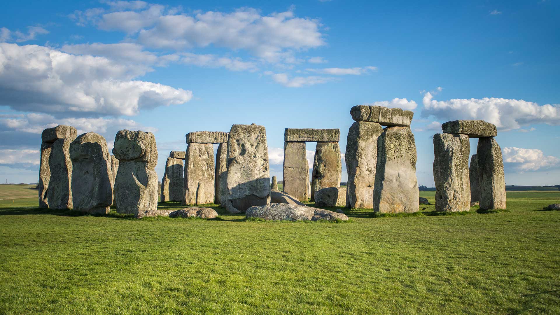 Towering pillars at Stonhenge with bright blue skies behind