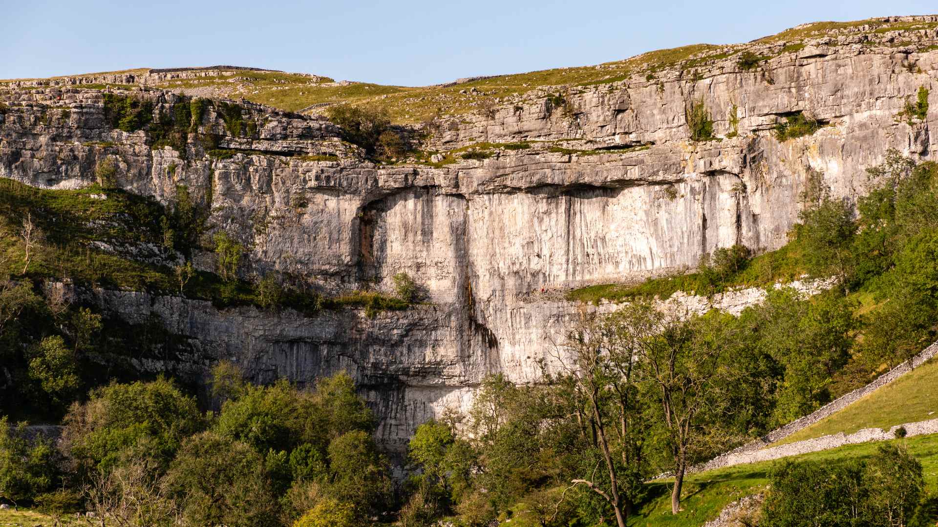 Malham Cove limestone cliff lit by the low summer sun